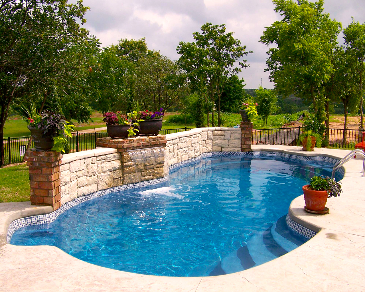 Fair Oaks Boerne Texas Fiberglass Pools by Lonestar Pool installs the Santa Fe model free form pool with entry steps, exit ladder and custom water features