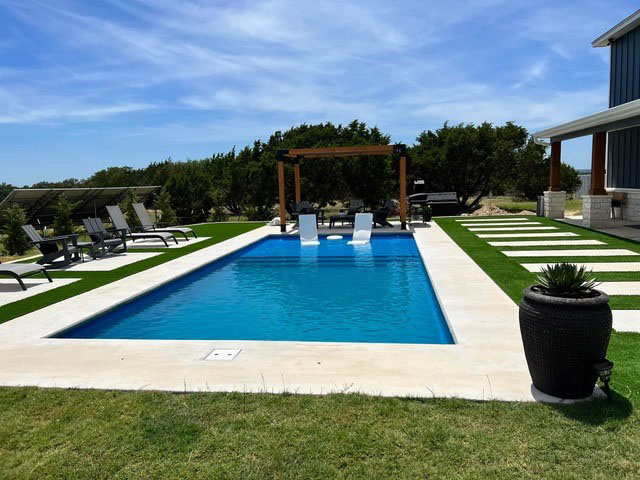 The Laguna Fiberglass Pools Austin by Lonestar beach entry tanning ledge custom concrete pool deck and coping plus elegant pergola