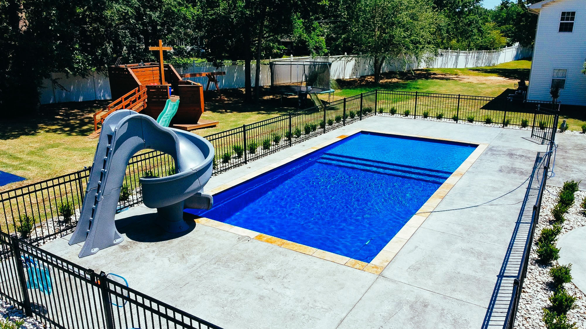 Laguna Fiberglass Pools San Antonio manufactured and installed by Lonestar Pool of New Braunfels salted concrete slide and safety fence