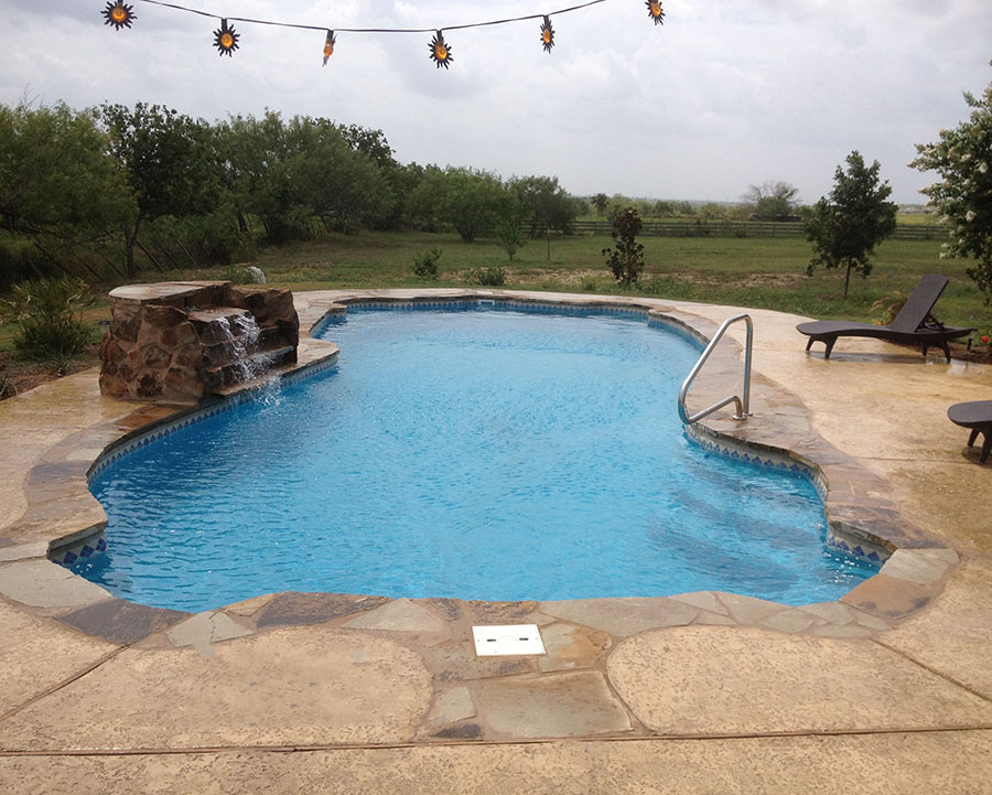 Fiberglass Pools Pelican Reef Mississippi Gulfport Style Pool with a waterfall that gives serenity to your private backyard resort with five stars